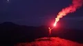 The man with a firework stick standing on a night mountain 4k or 4k+ Resolution