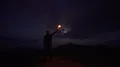 The man with a firework stick standing on the night mountain 4k or 4k+ Resolution