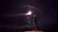 The man with a firework stick standing on a night mountain 4k or 4k+ Resolution