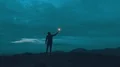 The man with a firework stick standing on the night mountain 4k or 4k+ Resolution