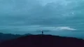 The man with the firework stick standing on a night mountain 4k or 4k+ Resolution