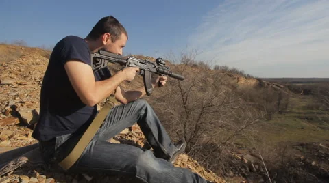 Man firing customised russian machine gun, wide Stock Footage 62605300