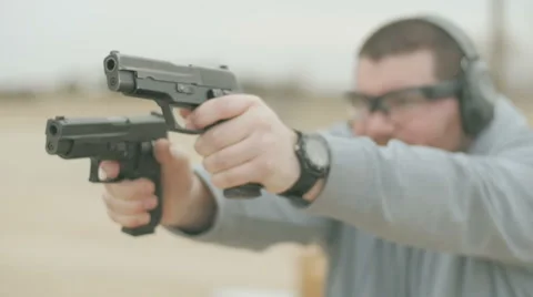 Man Firing Two Semi Automatic Handguns Stock Footage 60665308