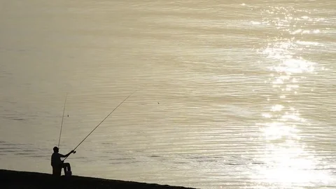 A man fishing from the beach Stock Footage 82600601