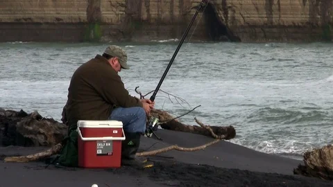 Man fishing on a beach Stock Footage 90210562