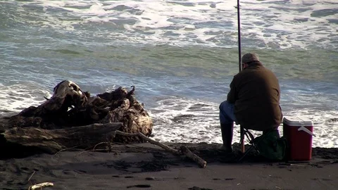 Man fishing on a beach Stock Footage 90210817