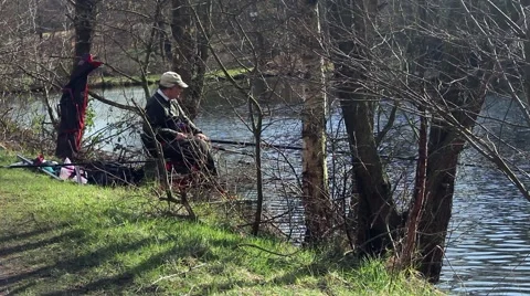 A man fishing in a forest pool Stock Footage 61393364