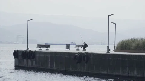 Man fishing in the harbor Stock Footage 166240628