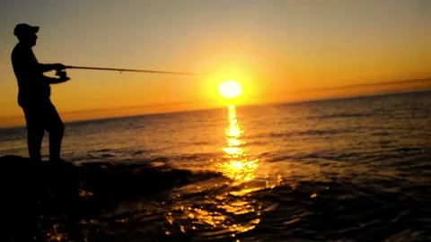 A man fishing with his reel in the sunrise HD Stock Footage