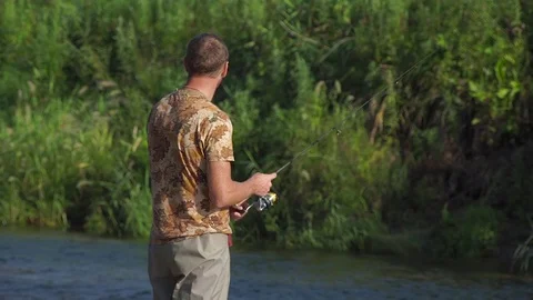 Man fishing on a mountain river with a short ultralight spinning Stock Footage