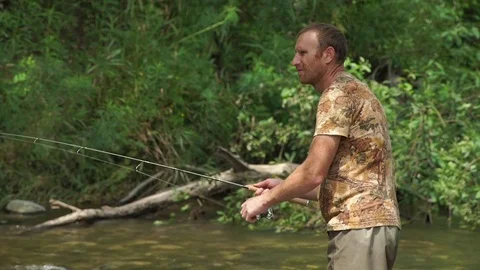Man fishing on a mountain river with a short ultralight spinning Stock Footage