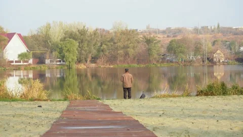 A man fishing while standing by the river Stock Footage 156736956