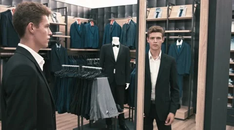 The man in the fitting room, looking in the mirror in shop Video stock 66428089