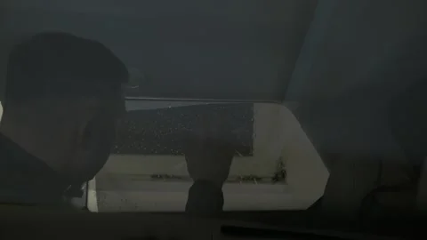 Man fitting tinting foil inside car side windows. Window Tinting Process Stock Footage 145730070