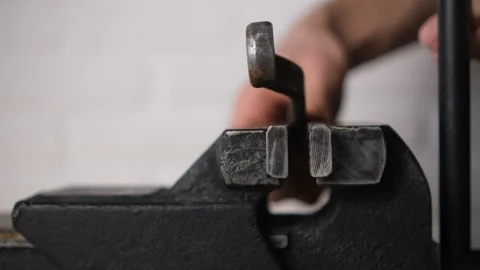 The man fixed the wrench in a black vice with a screw handle, Close-up, blurred  Stock Footage 146956448