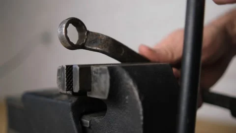 The man fixed the wrench in a black vice with a screw handle, Close-up, blurred  Stock Footage 149614804