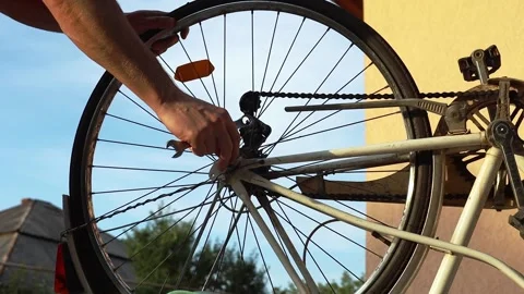 A man fixes a bicycle wheel Stock Footage 204043863