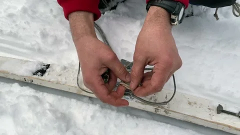 A man fixes a binding on a touring ski. Close-up of hands Stock Footage 179353938