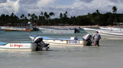 Man fixes boat engine at the harbor in Bayahibe, Dominican Republic. Stock Footage 58319622