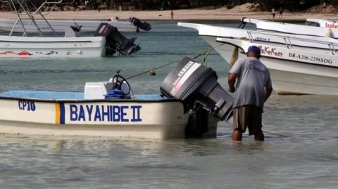 Man fixes boat engine at the harbor in Bayahibe, Dominican Republic. Video stock 58319646