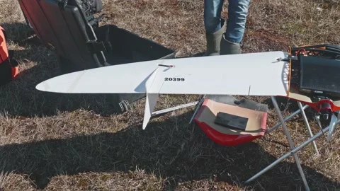 A man fixes flap on wing of drone to fly it. Tundra in Russia. Stock Footage 165757070
