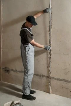 Man fixes a guide to align the walls with stucco Stock Photos