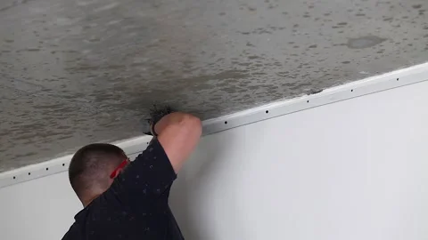 A man fixes a mount for a stretch ceiling. Stretch ceiling installation. Stock Footage 227946267