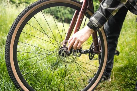 A man fixes a problem with a bicycle wheel, generative AI. Stock Photos