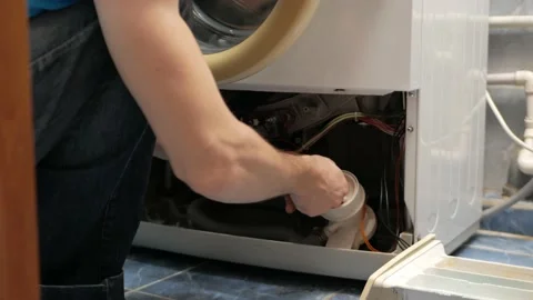 Man fixes washing machine, repairs, broken, destroyed. Bathroom, tools, repair Stock Footage 168375556