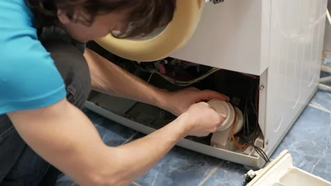 Man fixes washing machine, repairs, broken, destroyed. Bathroom, tools, repair Stock Footage 168375606