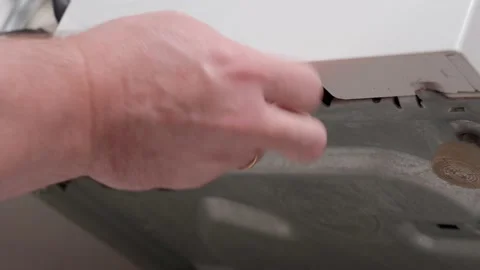 A man fixing a broken washing machine unscrews the bolt with a screwdriver 4K Stock Footage 165752039