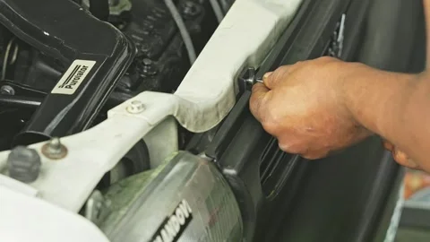 A man is fixing the bumper of the car after servicing it at the car repair sh Vídeos de archivo 245275930