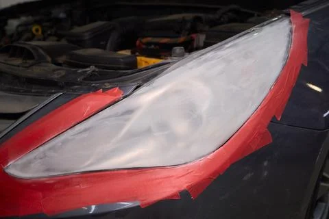 Man fixing car scratch precisely in repair shop, displaying craftsmanship in  Stock Photos