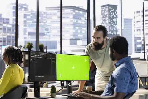 Man fixing coding mistakes on mockup computer, being assisted by colleague Foto stock