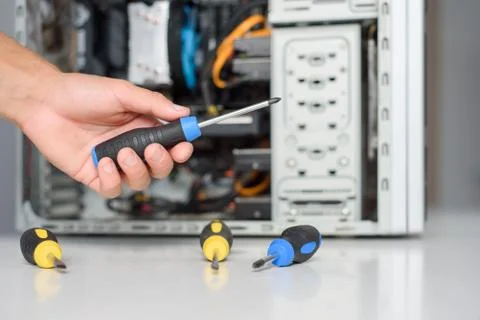 A man fixing a computer with screwdriver Stock Photos
