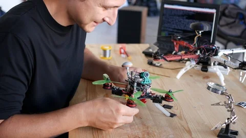 Man fixing a crashed drone. Quadrcopter service laboratory. 4K Stock Footage 90451436