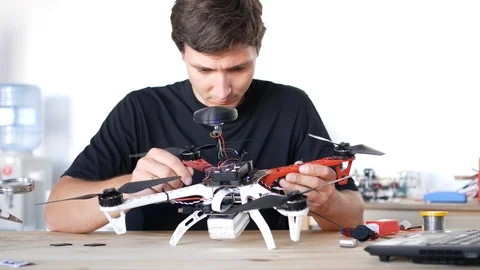Man fixing a crashed drone. Quadrcopter service laboratory. 4K Stock Footage 90451957