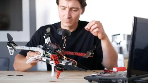 Man fixing a crashed drone. Quadrcopter service laboratory. 4K Stock Footage 90452067
