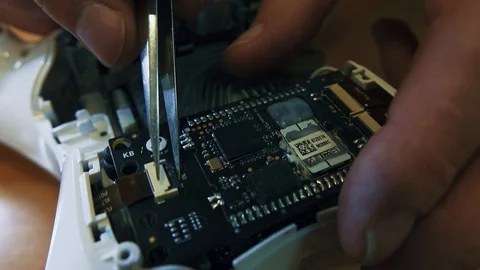 Man fixing a crashed drone. Quadrocopter service laboratory. Close up. 4K Stock Footage 86916059