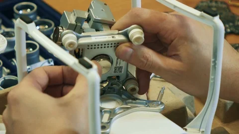 Man fixing a crashed drone. Quadrocopter service laboratory. Tracking shot. 4K Video stock 86927380