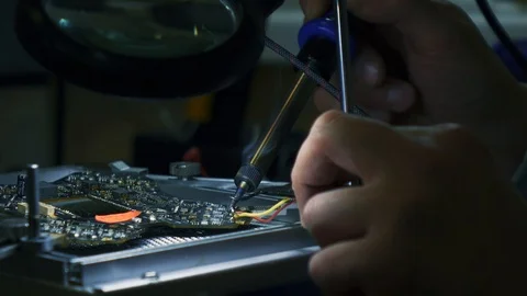 Man fixing a crashed drone with soldering iron. Tracking shot. Close up. 4K Stock Footage 86914547