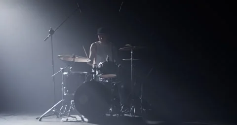 Man fixing earphone and playing beat on drums Video stock 249853341