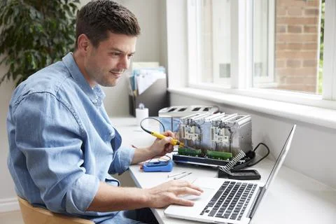 Man Fixing Electric Toaster Using Online Instructions Rather Than Buying New Foto stock