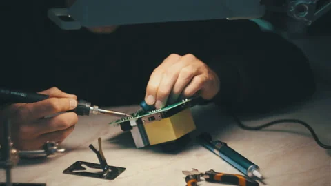 Man is fixing a electronic power unit with a soldering 스톡 동영상 166047982
