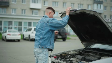 Man fixing engine, Man in faded jeans fixing car engine with confidence Stock Footage 329443286