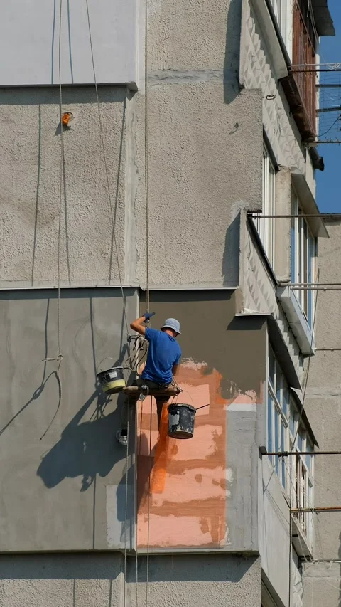 A man is fixing foam and netting on the balcony of a high-rise apartment bu.. Stock Footage 306148779