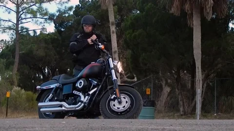 Man fixing helmet before getting on motorcycle, pulling off Vídeos de archivo 45248814