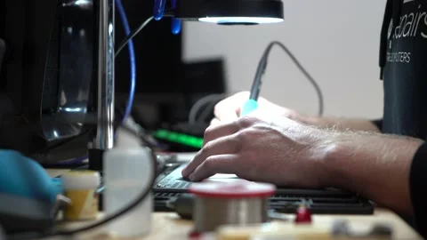 Man fixing up laptop micro soldering under microscope Stock Footage 162306355