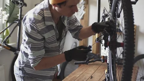 Man fixing a mountain bike in a workshop Stock Footage 277968599
