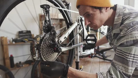 Man fixing a mountain bike in a workshop Stock Footage 277968804